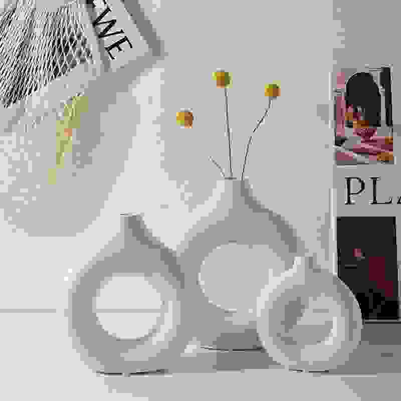 Trio of white NordicBloom™ Elegant Flower Vases Decorative Display with yellow floral stems, perfect for Scandinavian living room decor.